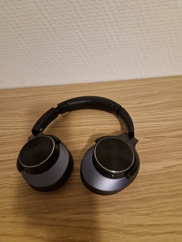 Fekete Oneodio fejhallgató egy fafelületen